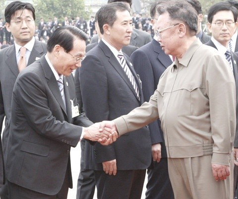 ▲ 김정일이 내민 한 손을 두 손으로 공손하게 부둥켜 쥐고 감읍하고 있는 김만복.