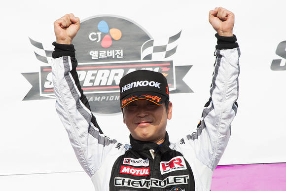 ▲ 쉐보레 레이싱팀 이재우 감독 겸 선수가 '2013 CJ 헬로비전 슈퍼레이스 챔피언십' 3라운드 우승 후 시상대에서 두 손을 번쩍 들어 환호하고 있다. ⓒ한국지엠