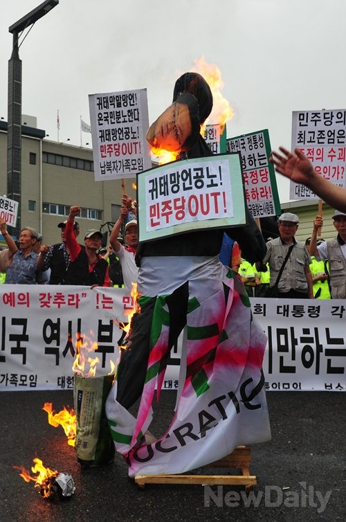 ▲ 민주당 중앙당사에 모인 보수시민단체 회원들은 홍익표 대변인의 사진을 건 인형을 불에 태우고 있다.ⓒ이종현