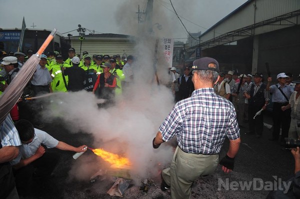 ▲ 민주당 중앙당사에 모인 보수시민단체 회원들은 홍익표 대변인의 사진을 건 인형을 불에 태우고 있다.ⓒ이종현