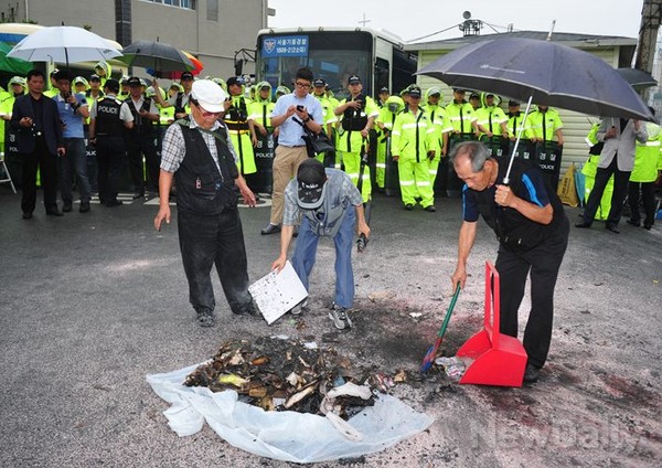▲ 민주당 중앙당사에 모인 보수시민단체 회원들이 민주당 홍익표 대변인의 모형 인형 화형식을 한 뒤 뒷정리를 하고 있다.ⓒ이종현