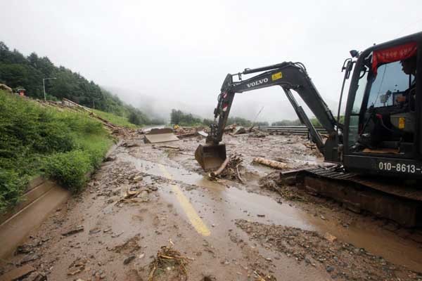 ▲ 산사태로 토사가 덮친 도로를 복구하는 모습.