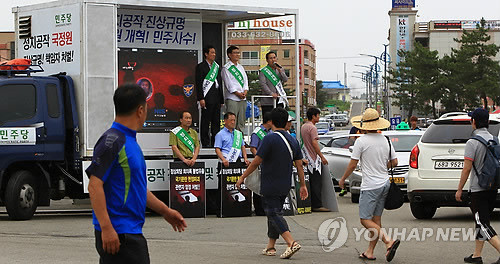▲ 2일 속초해수욕장 입구에서 민주당의 국정원 개혁운동 거리홍보전이 진행되고 있다. 행사장 앞을 피서객들이 지나가고 있다.ⓒ연합뉴스