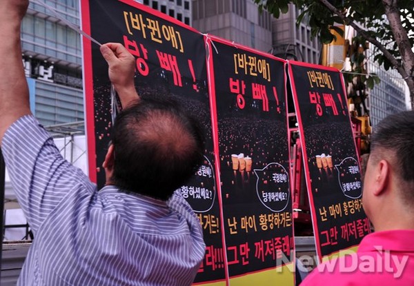 ▲ 촛불집회 선전물을 가로수에 매달고 있는 시민단체, 박근혜 대통령을 발음이 비슷한 '바뀐애'라 지칭하는 원색적인 문구가 눈에 들어온다.