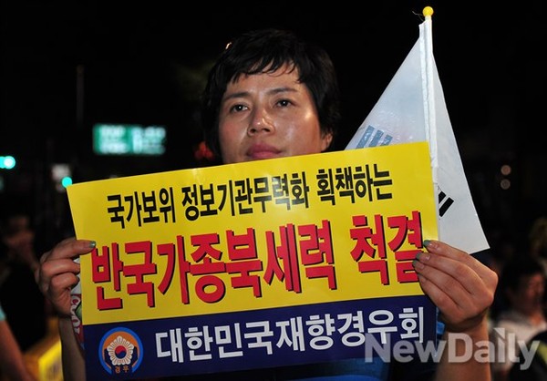 ▲ 집회에 참석한 한 여성이 피켓을 들고 서 있다.