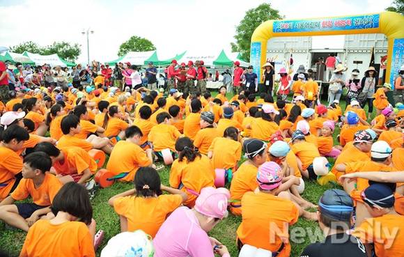 ▲ 뜨거운 8월의 태양 아래에 참가한 어린이들이 모여 앉아있다.