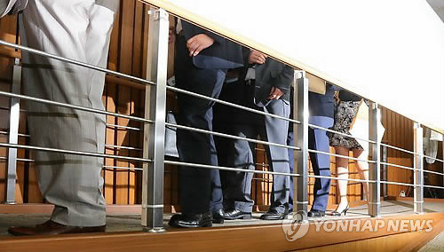 ▲ 19일 오전 국회에서 열린 국가정보원 댓글의혹 사건 규명을 위한 국정조사 특위 2차 청문회에서 댓글사건 당사자인 김모씨(오른쪽) 등 국정원직원 증인들이 오전 회의가 끝나고 정회가 선언되자 가림막 통로를 통해 청문회장에서 나가고 있다. ⓒ연합뉴스