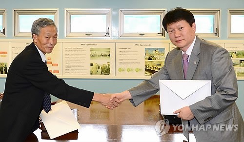 ▲ 29일 판문점 중립국감독위원회 회의실에서 구본석 남측연락관(오른쪽)과 정원찬 북측연락관이 '개성공단 남북공동위원회 구성·운영 합의서'를 교환하고 있다. 2013.8.29  ⓒ 연합뉴스