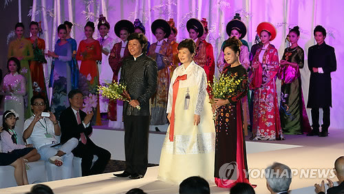 ▲ (하노이=연합뉴스) 도광환 기자 = 박근혜 대통령이 8일 오후 베트남 하노이 경남랜드 마크 72호텔에서 열린 한복-아오자이 패션쇼에서 무대위에 올라 양국 디자이너에게 꽃다발을 준뒤 환하게 웃고 있다.