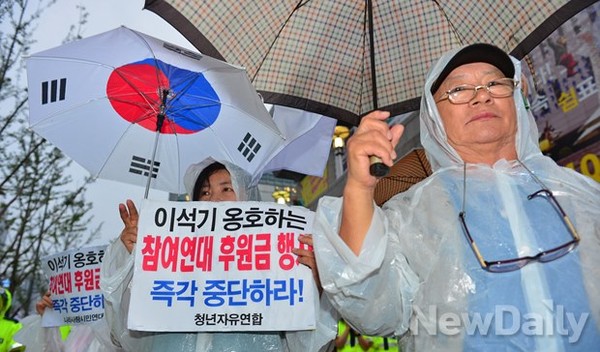 ▲ 지난 3년간 통합진보당의 이석기 의원을 조사한 국정원이 최근 그의 내란음모 혐의를 밝혀냈다. 그간 무조건적인 참여연대의 초 태우기 경연대회에 무관심했던 일부 시민들이 참여연대가 또 다시 후원금을 모아 촛불을 켜는 것에 반대하기 위해 참여연대 창립 19주년 행사가 열린 세종문화회관 세종홀 앞에서 시위를 하고 있다ⓒ정상윤