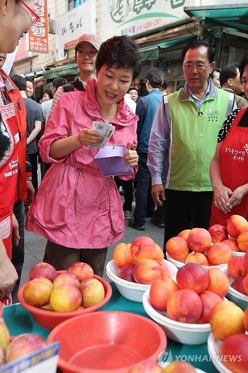▲ 박근혜 대통령이 17일 용인 중앙시장을 찾아 과일을 구입하고 있다. ⓒ연합뉴스