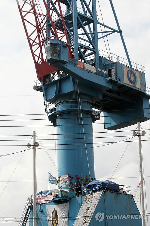 ▲ 지난 2011년 9월 12일 부산 영도구 봉래동에 위치한 한진중공업 영도조선소 크레인 상단부분에서 김진숙 민주노총 부산지역본부 지도위원이 250일째 점거농성을, 하단에는 4명의 해고자가 80일째 농성을 벌이고 있다.ⓒ연합뉴스