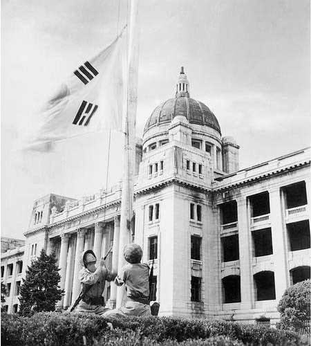 ▲ 1950년 9월 27일 오전 6시 10분, 서울 중앙청 앞에 국기를 게양하고 있는 해병대원.