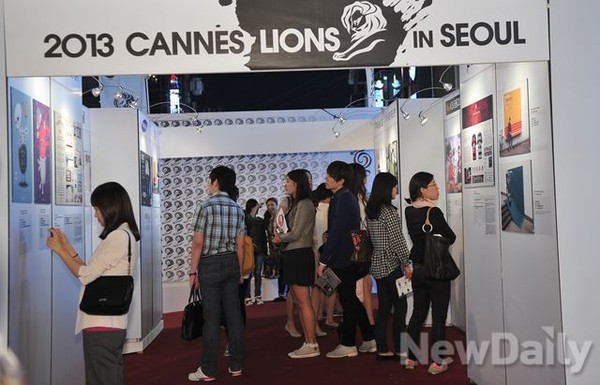 ▲ 홍대주차장거리에서 진행되고있는 전시회에서 작품들을 유심히 지켜보는 관객들