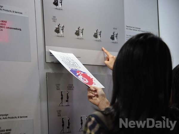 ▲ 전시회의 작품을 손짓까지 하며 유심히 관람하는 관객