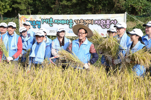 ▲ 이순우 우리은행장(오른쪽 다섯번째)을 비롯한 임직원 100여명이 17일 경기도 안성에 위치한 자매결연 마을에서 가을걷이 자원봉사 활동을 하고 있다. ⓒ우리은행