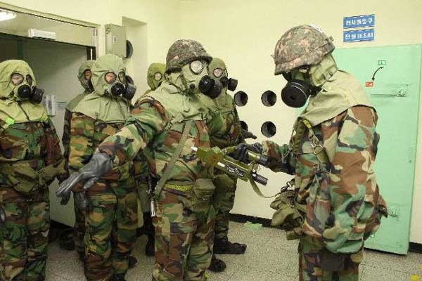 ▲ 화생방 방호복을 입은 장병들. 이 장비로는 생물학 무기와 방사능을 막기 어렵다. [사진: 연합뉴스]