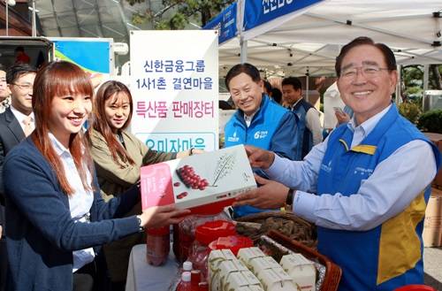 ▲ (사진제공=신한금융그룹) 신한금융그룹이 자매결연 농촌마을 농산물 판매를 통해 농촌 돕기와 소외계층 돕기에 발 벗고 나섰다. 사진은 한동우 신한금융 회장(오른쪽 첫번째)과 서진원 신한은행장(오른쪽 두번째)이 시민에게 결연 마을 농산물을 직접 판매하는 모습.