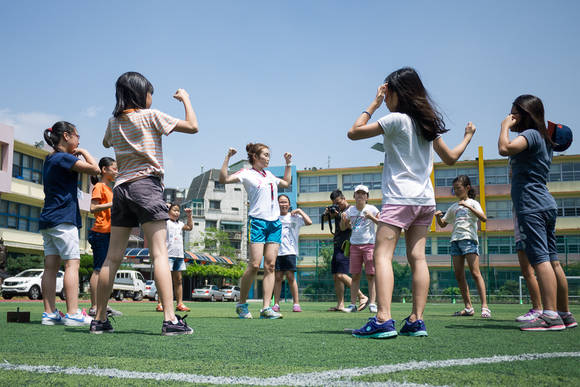 ▲ 현대해상 주관의 사회공헌 활동 [소녀 달리다]에 참여한 학생들이 운동장에서 코치와 함께 몸을 풀고 있다.