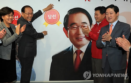 ▲ 황우여 새누리당 대표가 30일 오후 서울 여의도 당사에서 경기 화성갑, 경북 포항 남·울릉 두 곳에서 치러진 재·보궐선거의 승리가 확정되자 서청원-박명재 후보 사진 옆에 당선 스티커를 붙이고 있다. ⓒ연합뉴스