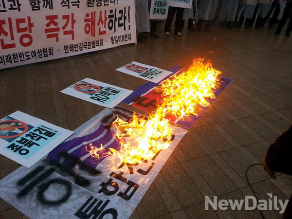 ▲ 6일 시청광장에 모인 국민들이 통합진보당의 해산을 촉구하며 통합진보당의 깃발을 불지르고 있다(photo by 윤희성 기자의 갤럭시 스마트폰)