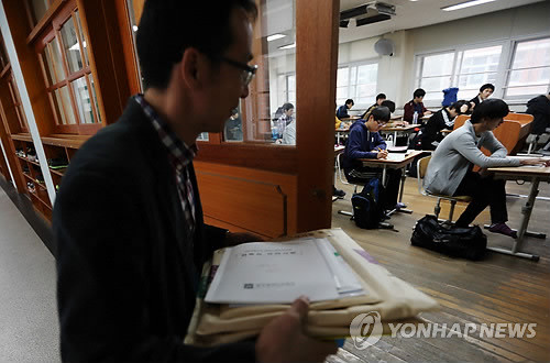 ▲ 수능시험지를 들고 교실에 입장하는 감독관 ⓒ연합뉴스