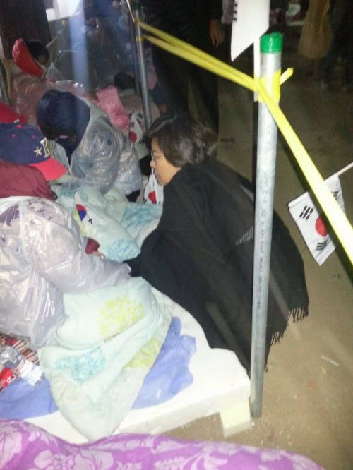 ▲ 이혜훈 새누리당 최고의원이 수원지법을 찾아 강추위 속에서도 방청권 사수를 위해 밤샘 노숙을 하고 있는 통일미래연대 탈북자들을 격려하고 있다. ⓒ 블루투데이