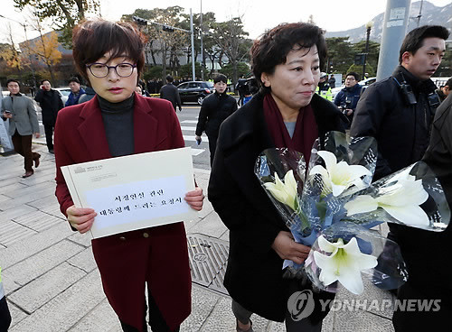▲ 은수미(왼쪽), 남윤인순 민주당 의원이 17일 청와대 분수대 앞에서 진실을 의미하는 백합꽃과 박근혜 대통령의 시정연설 관련 요청서를 들고 청와대로 향하고 있다.ⓒ연합뉴스