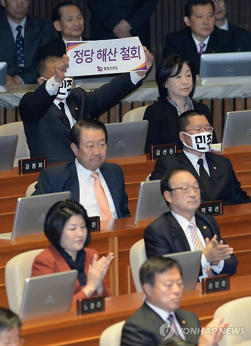 ▲ 김선동 통합진보당 의원이 18일 국회 본회의장에서 박근혜 대통령이 시정연설을 하는 동안 정당해산 반대 수기를 들어 보이고 있다.ⓒ연합뉴스