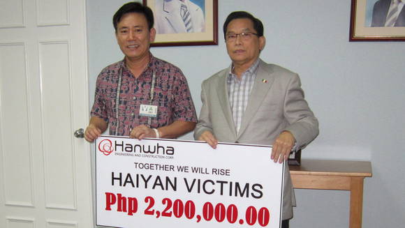 ▲ 필리핀 아레나 공연장 신축공사현장 하권호 상무(좌측)가 INC측에 재해지원금을 전달하는 모습. 사진제공:한화건설