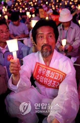 ▲ 2008년 5월 서울 청계광장에서 광우병 쇠고기 반대하는 국민대책회의 주최로 열린 떼촛불 집회에서 강기갑  민주노동당 의원이 촛불을 들고 있다.ⓒ연합뉴스