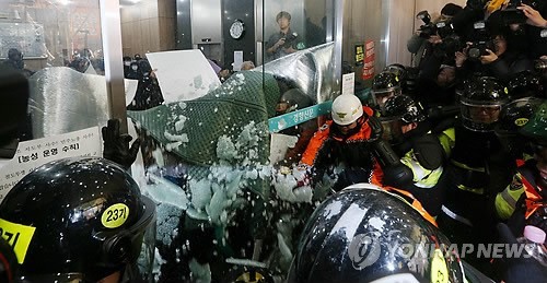 ▲ 김명환 위원장 등 철도노조 집행부에 대한 경찰의 체포영장 강제 집행이 시작된 22일 오전 서울 정동 민주노총 건물 1층에서 경찰과 소방대원들이 로비로 연결되는 자동문을 깨고 있다. 2013.12.22 ⓒ 연합뉴스