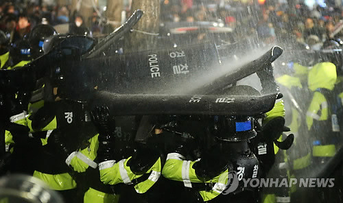 ▲ 경찰은 22일 오전 체포영장이 발부된 철도노조 집행부 검거에 나섰다. 서울 중구 정동 경향신문사 사옥 앞에서 법집행을 거부하는 노조원들의 [떼거리 뗑깡]은 무법 난장판이었다. 소방호스를 이용한 물대포로 경찰을 되레 공격하고 있다.ⓒ 연합뉴스