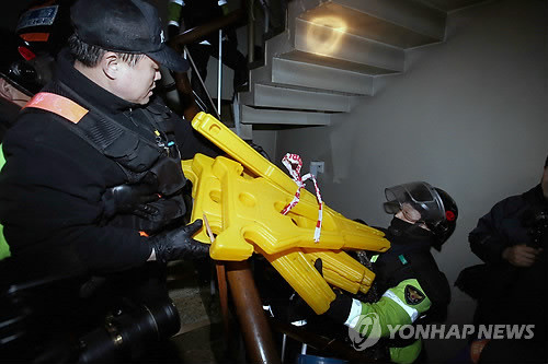 ▲ 철도노조 집행부에 대한 체포영장 집행을 위해 서울 중구 정동 경향신문사 사옥에 진입한 경찰이 공무집행 방해를 위해 노조원들이 쌓아 놓은 바리게이트를 치우고 있다.ⓒ 연합뉴스