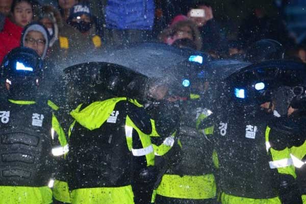 ▲ 지난 12월 22일 민노총 본부에 진입하려는 경찰들에게 민노총 관계자들이 소화전의 물을 뿌리고 있다.