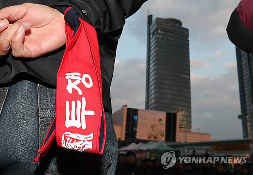 ▲ 지난해 말 철도노조 조합원이 팔목에 투쟁 구호가 적힌 띠를 매고 대전 코레일 본사 인근에서 시위를 벌이고 있다.ⓒ 연합뉴스