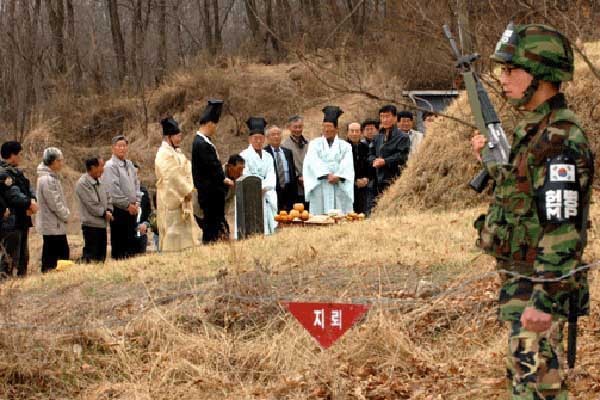 ▲ 민통선 북쪽 지역에서 성묘를 하는 사람들과 경계를 서는 병사.