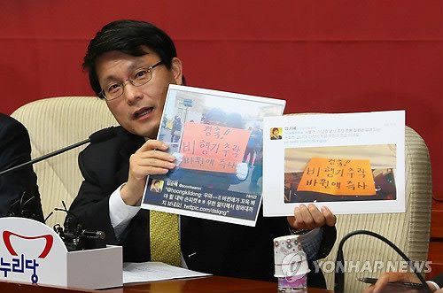 ▲ 윤상현 새누리당 원내수석부대표가 21일 오전 국회에서 열린 원내대책회의에서 임순혜 방송통신심의위원회 보도교양방송특위 위원이 트위터에서 리트윗한 시위 피켓 사진을 공개하고 있다.ⓒ연합뉴스