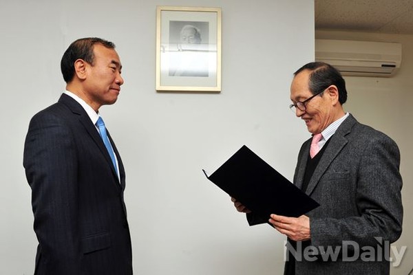 ▲ 한상대 [뉴데일리] 고문(왼쪽)이 인보길 [뉴데일리] 대표이사(오른쪽)로부터 위촉장을 받고 있다. 뒤 벽면엔 [우남] 사진이 걸려있고, 우측 뒤엔 [우남]이 쓴 편액 복사 액자가 세로로 세워져 있는 등 [뉴데일리] 발행인 사무실은 사방이 [우남] 관련 자료로 가득차 있다.ⓒ 이종현 기자