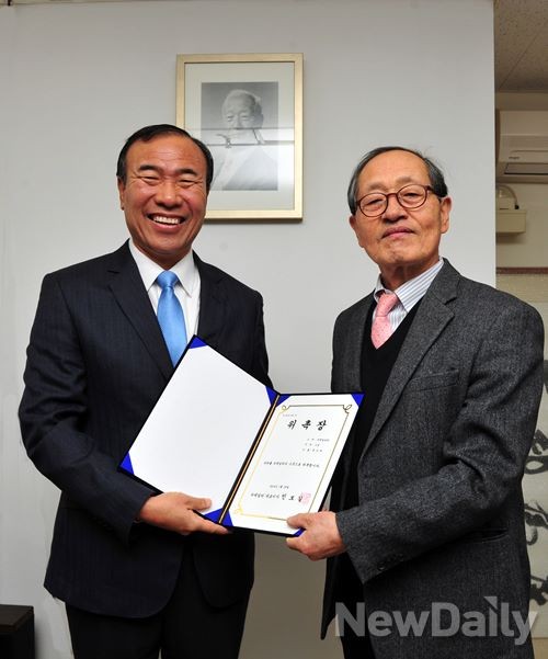 ▲ 한상대 [뉴데일리] 고문(왼쪽)이 인보길 [뉴데일리] 대표이사(오른쪽)로부터 위촉장을 받고 기념사진을 찍고 있다. 뒤 벽면엔 [우남] 사진이 걸려있고, 우측 뒤엔 [우남]이 쓴 편액 복사 액자가 세로로 세워져 있는 등 [뉴데일리] 발행인 사무실은 사방이 [우남] 관련 자료로 가득차 있다.ⓒ 이종현 기자