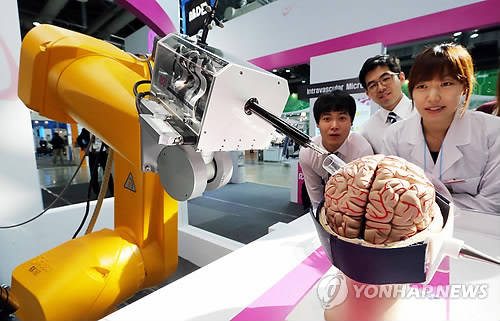 ▲ 지난 2012년 열린 로보월드2012에서 전남대 로봇연구소 연구원들이 단일경로 뇌수술로봇을 선보이고 있다.ⓒ연합뉴스