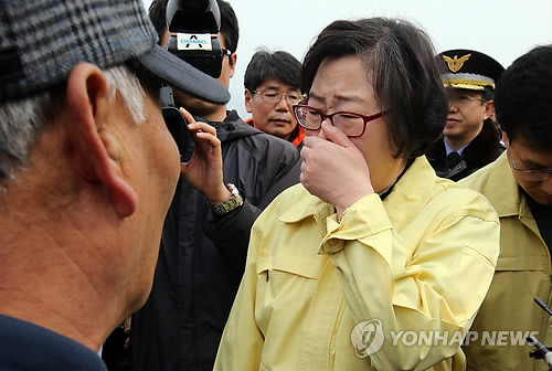 ▲ ▲ 윤진숙 해양수산부 장관이 1일 오전 전날 오전 원유 유출사고로 인한 기름띠가 밀려온 전남 여수시 신덕마을을 방문하는 도중 코를 막고 있다.