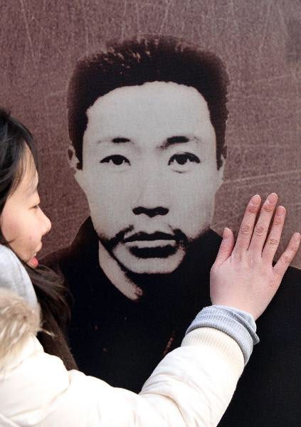 ▲ 안중근 의사 순국 100주기를 하루 앞둔 2010년 3월 25일 서울 청계광장에서 열린 안중근 특별전에서 한 시민이 안중근 의사의 사진을 손으로 어루만지고 있다. ⓒ 조선닷컴