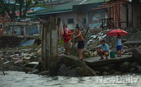▲ 해안가 주민들. 낚시대 없이 낚시줄을 던져 낚시를 하고있다 ⓒ 뉴데일리 정상윤