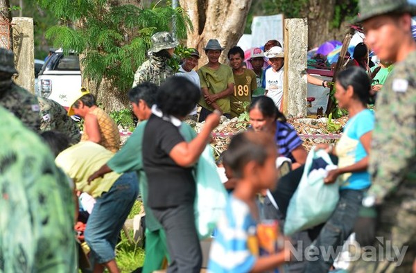 ▲ 여성과 아이들 우선순으로 구호물품을 전달한다. 남자들은 밖에서 구경만해도 즐겁다   ⓒ 뉴데일리 정상윤