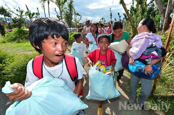 ▲ 미리 나눠준 가방에 한 가득 구호물품을 담아 돌아가는 필리핀사람들. 고마운 마음을 '감사합니다'로 표현한다  ⓒ 뉴데일리 정상윤