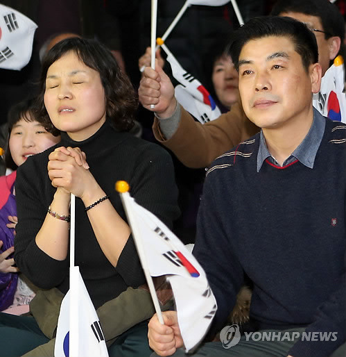 ▲ 여자 쇼트트랙 김아랑(19·전주 제일고) 선수가 18일 올림픽 3천m 계주에서 금메달을 따자 부모인 김학만, 신경숙씨와 주민들이 전북 전주시 서서학동 주민센터에서 환호하고 있다ⓒ연합뉴스