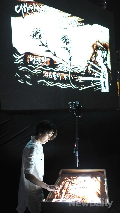 ▲ 샌드 아티스트(Sand Artist) 박선경 씨가 26일 오후 청계광장에서 열린 천안함 4주기 추모제에서 모래로 [나라를 위한 숭고한 희생 ‘절대’ 잊지 않겠습니다], [자유통일 ‘반드시’ 이루겠습니다]란 글씨를 만들고 있다. ⓒ 이미화 기자