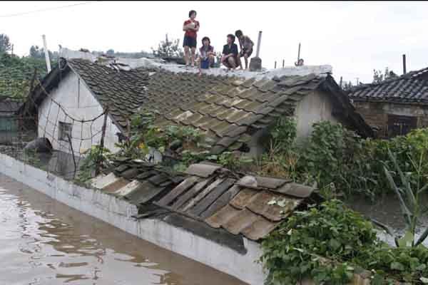 ▲ 홍수를 당한 북한 주민들이 지붕 위로 대피해 있다.[사진: 김성일 서울대 교수 제공]