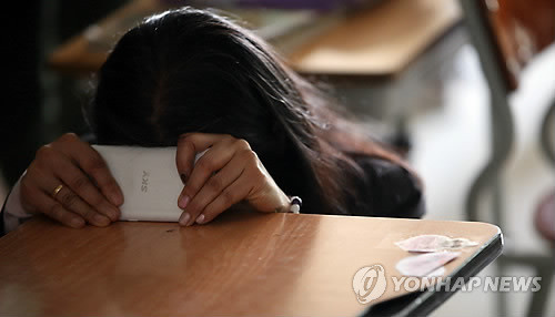 ▲ 17일 오전 경기도 안산 단원고등학교에서 한 어머니가 전남 진도 해상에서 실종된 자신의 친구 아들의 책상을 붙잡고 꼭 돌아오길 기원하고 있다. ⓒ연합뉴스